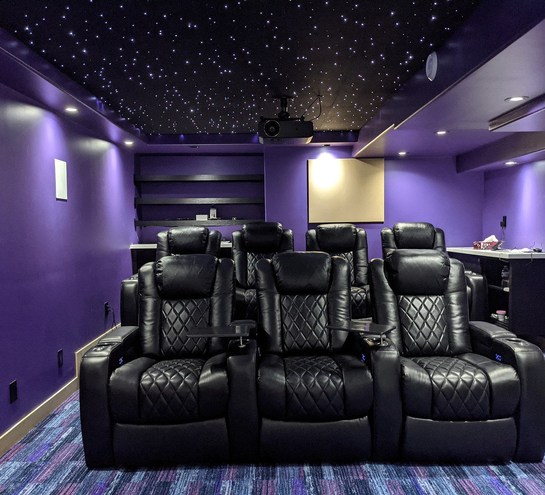 Narrow purple home theater with black recliners and a white starlight ceiling