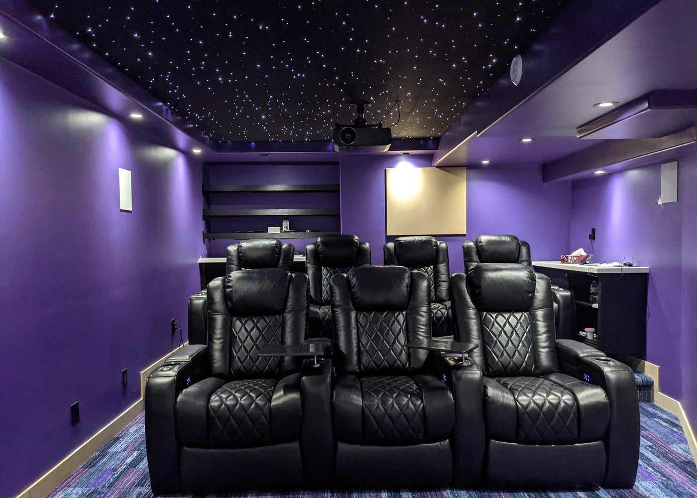 Purple home theater with a bright star-filled ceiling above two rows of seats