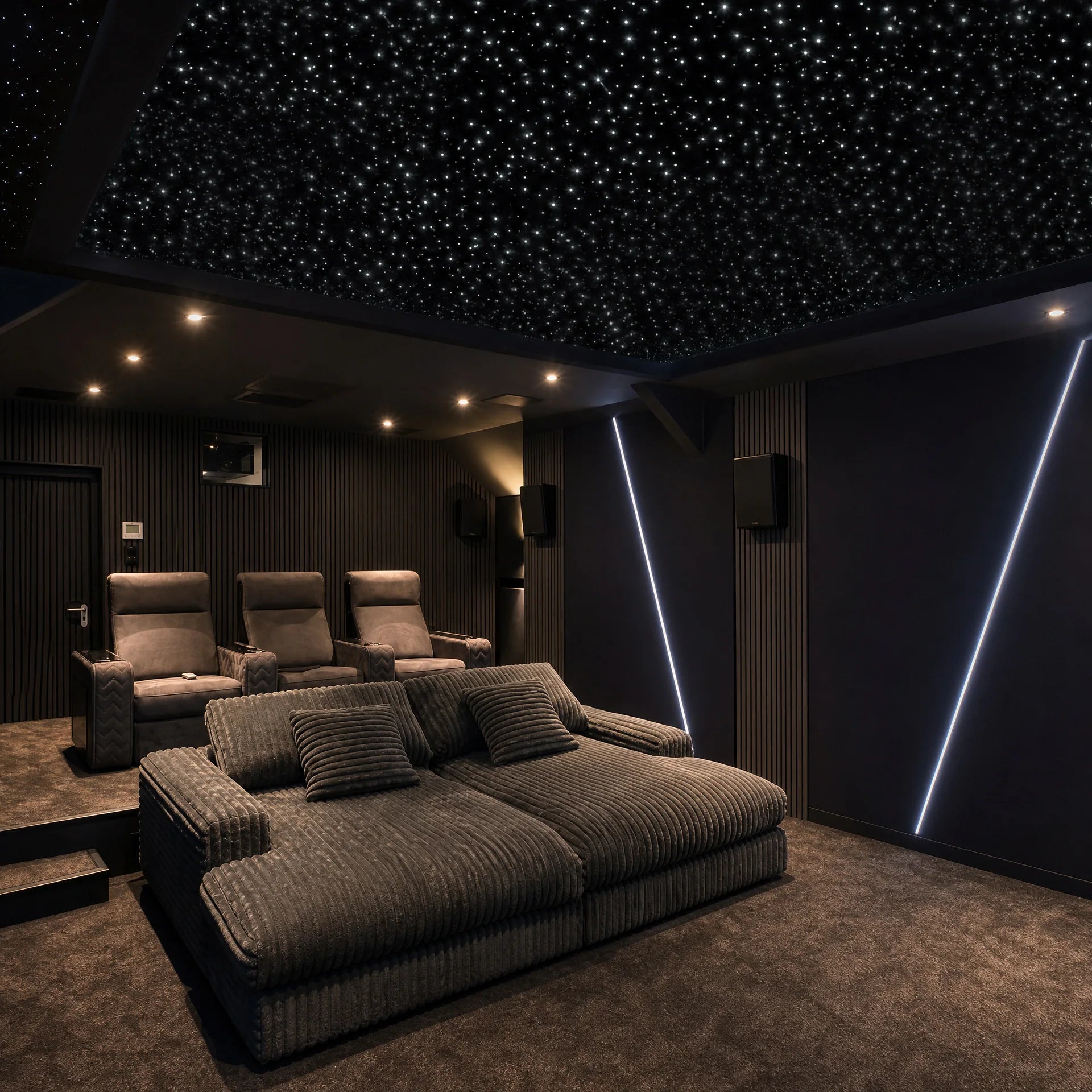 Dark modern home theater with recliners, lounge seating, and a white starlight ceiling