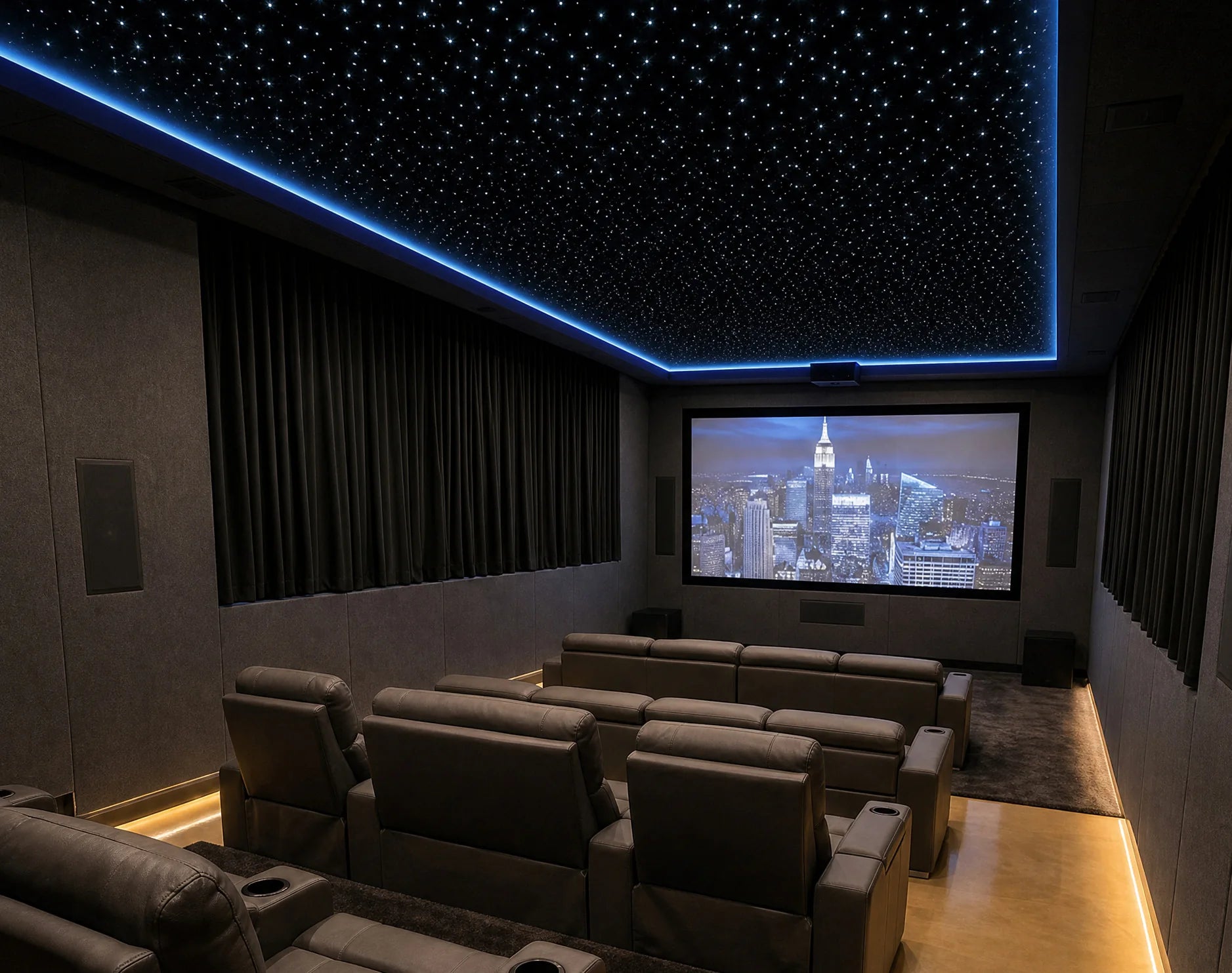 Large dark home cinema with tiered seating, blue cove lighting, and a starlight ceiling